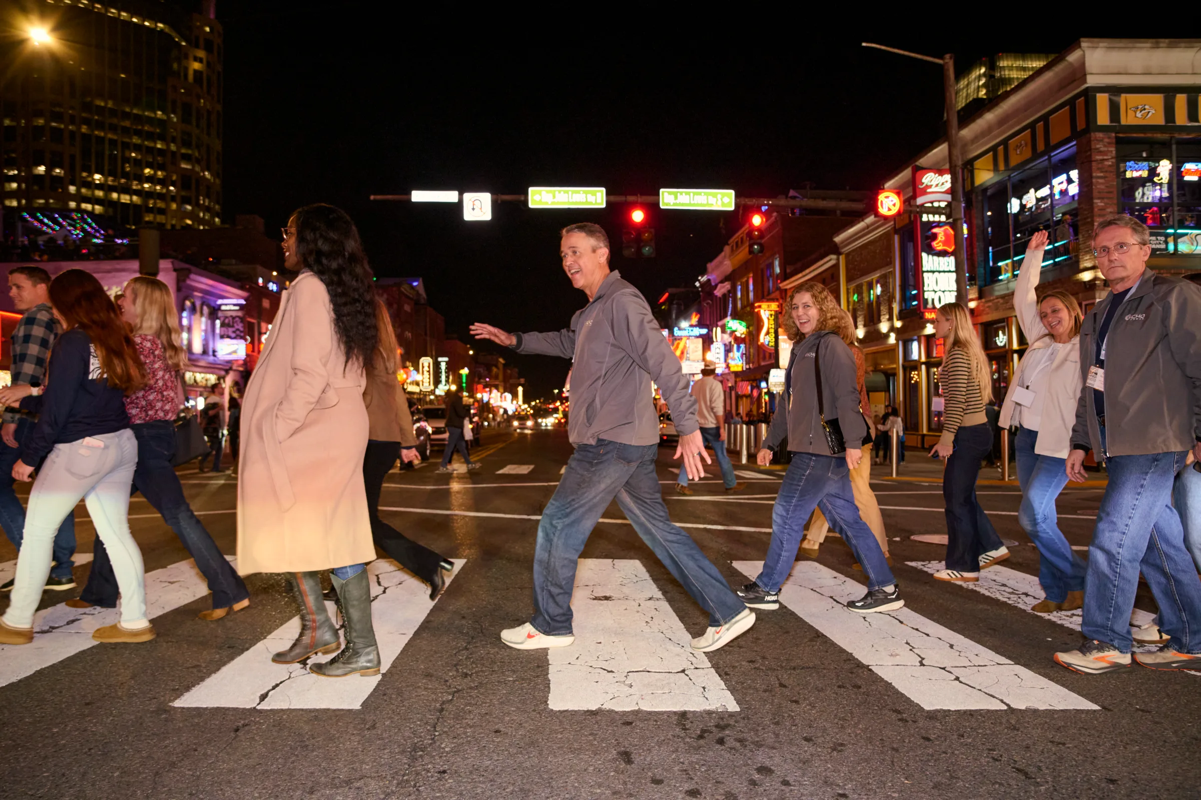 People crossing a busy street at night in Nashville.