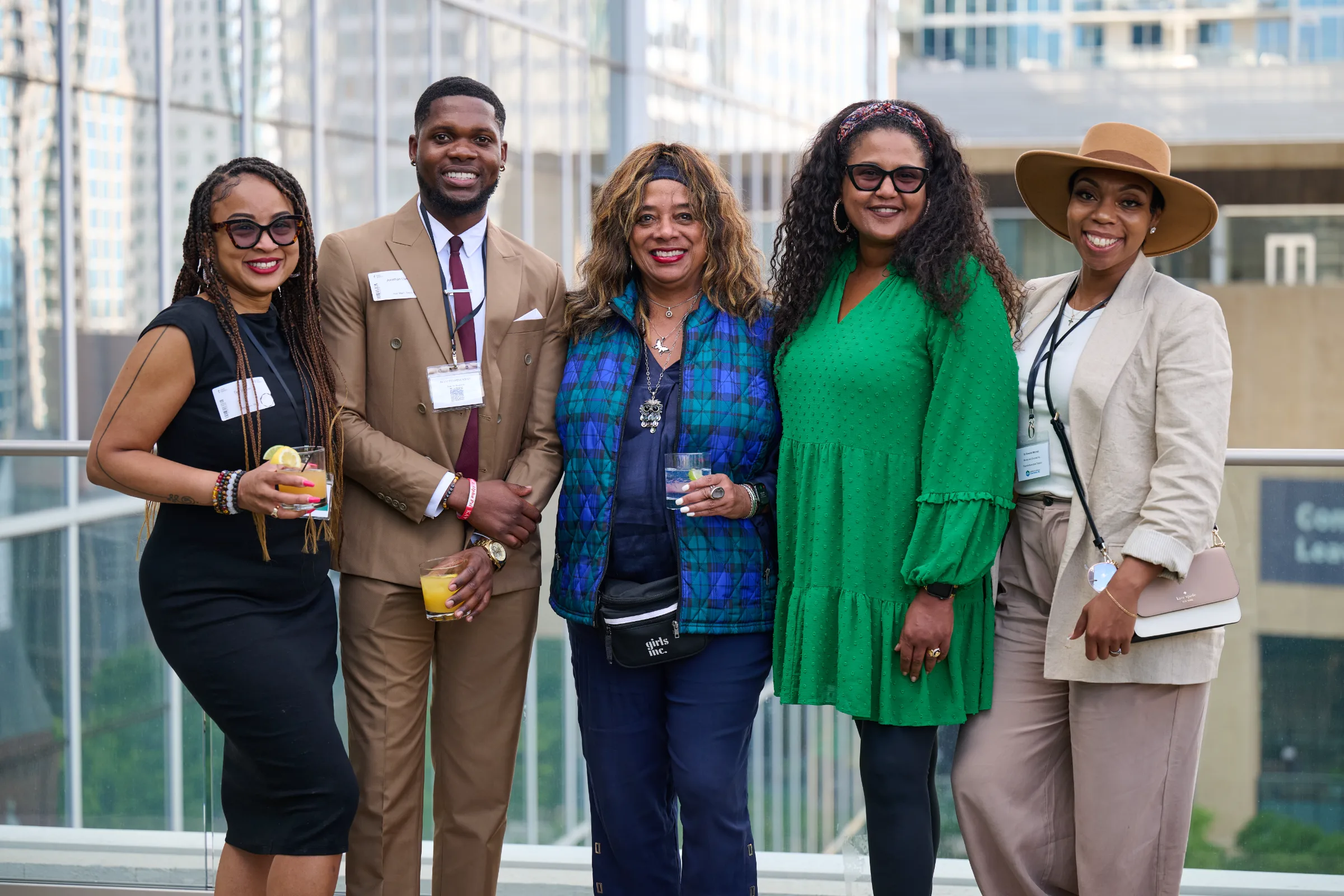Group of five professionals posing together at an outdoor event.